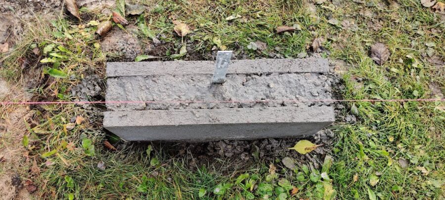 Punktfundament færdigstøbt, med grus sand og cement. Altså beton. der sidder i midten et anker som skal bruges når selve bundremmen skal skrues fast til punktfundamentet.